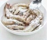 椒盐虾,把虾放入盘中,淋入<a style='color:red;display:inline-block;' href='/shicai/ 718'>料酒</a>搅匀后,撒入干淀粉搅匀,使淀粉能够均匀的包裹在虾身上