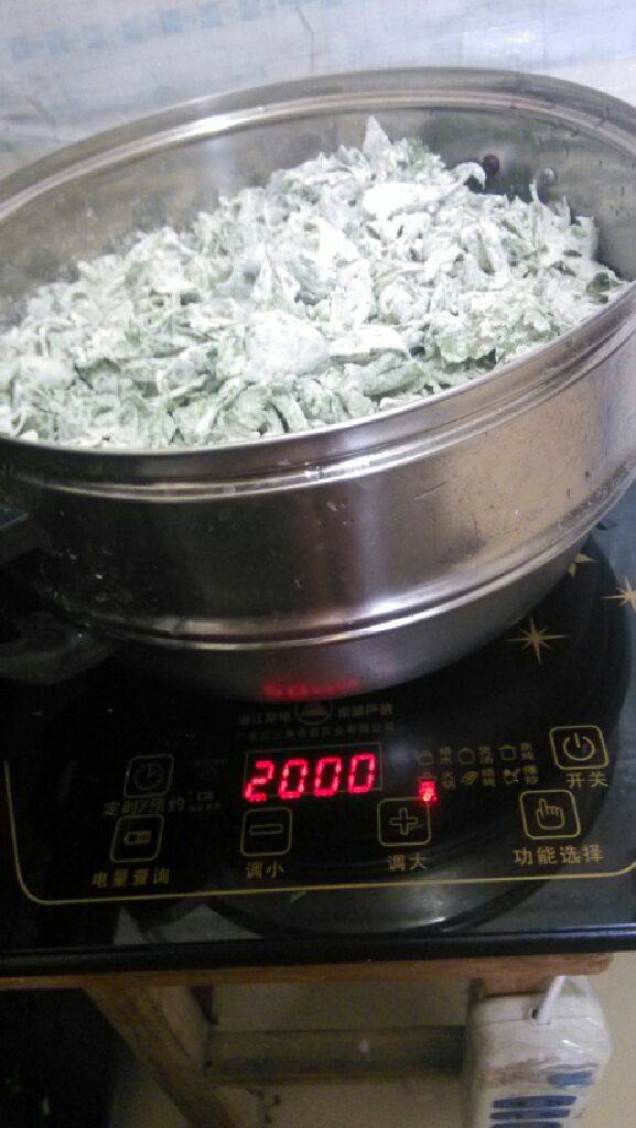 蒸芹菜叶,在蒸锅内铺上一块布,然后把芹菜叶,倒入锅中 上锅蒸。