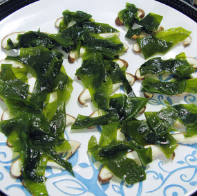 裙带菜清蒸剁椒黄花鱼,另取一大盘子,将香菇片码底,上面垫上切好裙带菜的。依次摆放好。