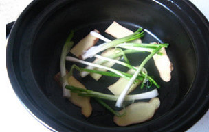 三杯中虾煲,切好的<a style='color:red;display:inline-block;' href='/shicai/ 37'>姜</a>片平铺在瓦煲底部，加入葱白
