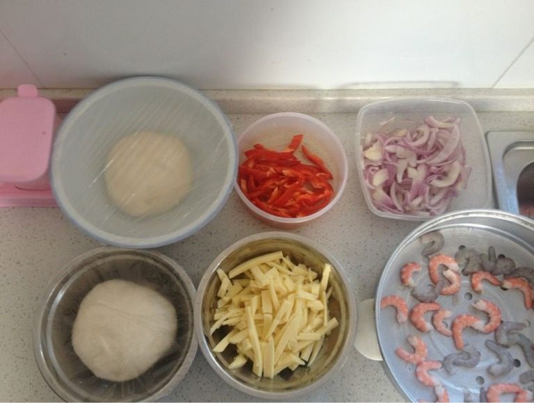 蛋Q虾仁小披萨,首先将<a style='color:red;display:inline-block;' href='/shicai/ 550'>高筋面粉</a>，酵母粉，<a style='color:red;display:inline-block;' href='/shicai/ 156925'>水</a>放入器皿中进行充分的搅拌，至光滑成团，用保鲜膜封闭，放入冰箱醒30分钟。 然后利用醒面的时间，处理好<a style='color:red;display:inline-block;' href='/shicai/ 29'>洋葱</a>，红绿彩椒和马苏里拉的清洗切丝工作。 最后清洗虾仁，沥<a style='color:red;display:inline-block;' href='/shicai/ 156925'>水</a>至干。