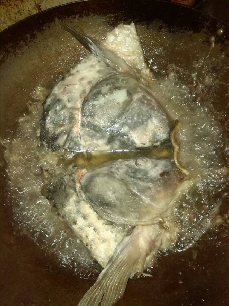 鲤鱼头炖豆腐,把鱼头挂生粉炸透