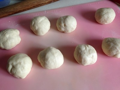 紫薯早餐包,搅拌程序结束，成不沾手的面团，无需等待发酵。

直接取出面团，利用刮板分割成重量基本相等的N分(约50克一份)，将小面团团成圆球，盖上保鲜膜，注意间距离开些摆放好。