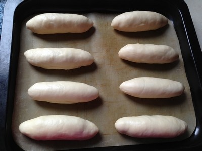 紫薯早餐包,整形好的面包胚摆入铺好烤布的烤盘，盖保鲜膜发酵40分钟。