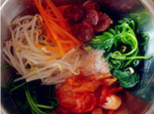 韩式拌饭,米饭放入盆内，铺上蔬菜、香肠、辣白菜，撒些<a style='color:red;display:inline-block;' href='/shicai/ 666'>芝麻</a>。