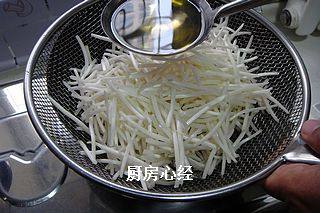 豆豉鲮鱼绿豆芽,豆芽菜一定反复控干水分,放入漏勺中,锅中放油,烧到6成热时,浇第一遍油;将漏勺中的豆芽菜翻动一下,再浇第二遍油