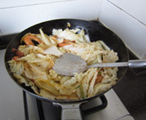 鲜虾炒白菜,下入葱姜蒜,煸炒出香味;下入白菜叶,转大火煸炒,一边炒一边用锅铲压白菜