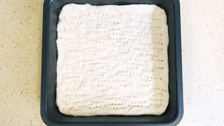 黑胡椒牛排披萨,烤盘淋上少许油,将面团平铺在盘中,插上均匀的小孔