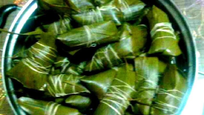 自制家庭粽子,盖住粽叶的左右两端.用线多缠几道，绑好就可以了，我包了两种，咸蛋黄的，板栗肉陷的，包法都是一样的，也可以蒸，我是煮的，把包好的粽子放入容器煮五十分钟就可以吃了