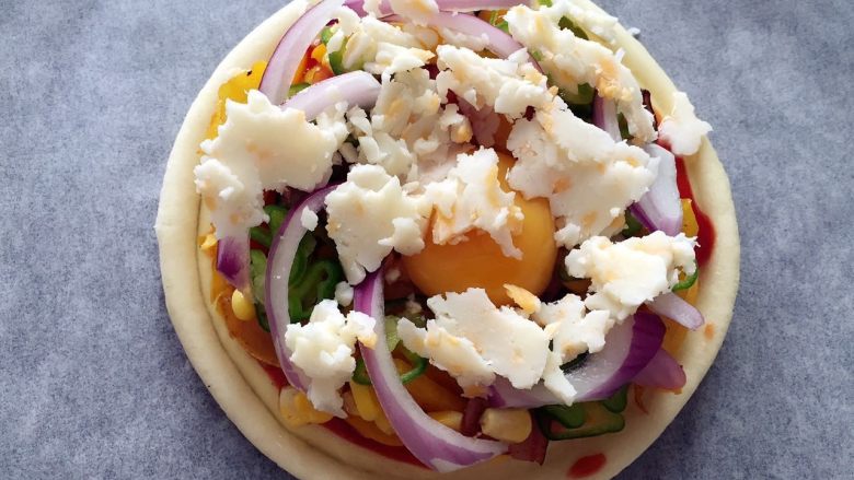 培根彩蔬披萨饼 ,快速撒上荷氏农场混合芝士碎
放入烤箱