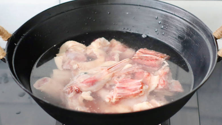 铁锅炖大鹅,锅中倒入适量的清水,放入洗净的鹅肉块。