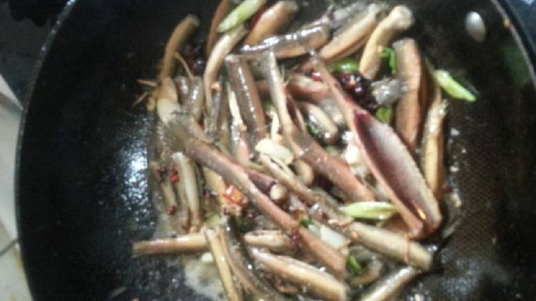 西红柿炖泥鳅,到入泥鳅,加料酒,盐,炒至微焦黄。