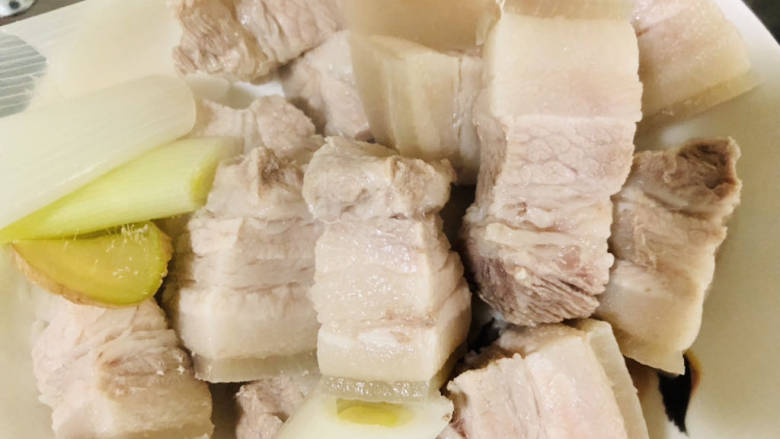 五花肉焖莲藕,捞出用温水冲掉浮沫,控干水分。