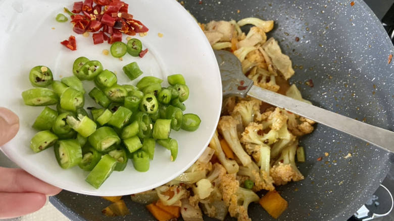 干锅菜花五花肉,加入线椒小米辣,中火翻炒断生