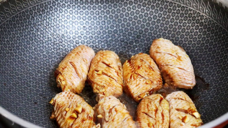 蒜香焖翅,锅中倒入少许食用油烧热,放入腌制好的鸡翅