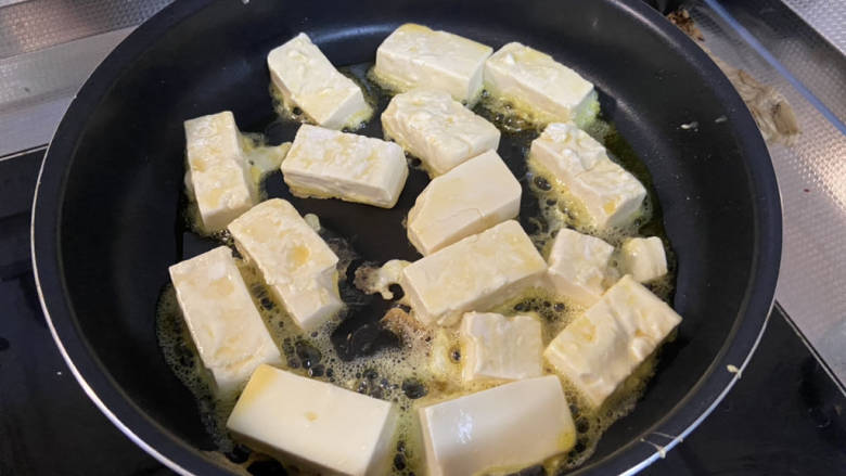 黄瓜烧豆腐,平底锅烧热加适量食用油,豆腐表面拍淀粉再裹蛋液,下锅中小火煎