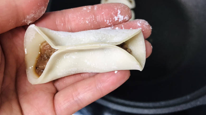 牛肉锅贴,馅放在皮的正中间,皮对折捏,中间粘在一起就行,两边不用封口;