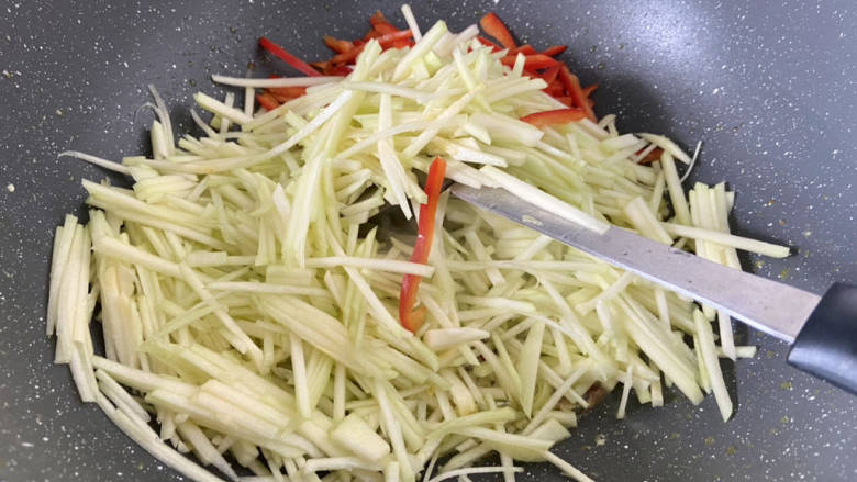 嫩南瓜炒肉丝,转中大火,加入红椒丝南瓜丝,翻炒一分钟