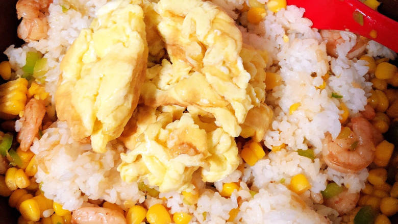玉米虾仁蛋炒饭,加入鸡蛋,炒匀入味。