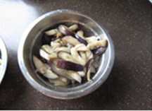 茄子豆角,原油中小火继续煸炒茄子;炒至茄子变软,盛出备用