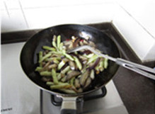 茄子豆角,原油爆香姜蒜片;加入干红辣椒段,煸炒至辣椒呈深枣红色;下入茄子和刀豆,大火煸炒至熟