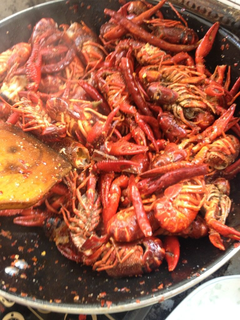 香辣小龙虾,如图锅中倒入食用油烧热将洗好的小龙虾倒入锅中爆炒,加入少许香醋、食用盐、翻炒加入茴香及生姜片炒香加入干辣椒焖半分钟倒入啤酒半分钟后加入温水少许焖制十分钟加入葱花即可