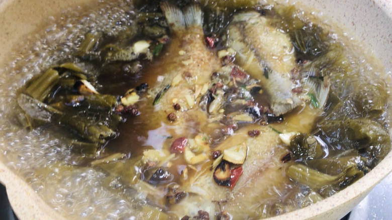 酸菜炖鲫鱼,放入鲫鱼拌匀煮沸,继续炖煮10分钟