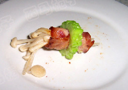 苦瓜培根金针菇卷,取一片培根放入盘中，取一撮金针菇放在培根上，从一头卷起来，再把卷好的培根卷塞入苦瓜圈中即可