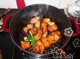 梅菜芋香红烧肉,大火把汤汁烧开后调成小火,然后放入梅菜、葱结和姜片,加盖焖约30分钟。然后,再次调成大火力将汤汁收浓