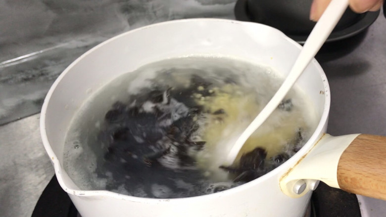 鲜虾木耳小米粥,放入小米锅中,拌匀煮沸,转小火炖煮至熟烂