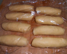 韩国小馒头,用擀面杖擀成牛舌形。卷起，盖保鲜膜，松弛下