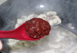 韩式辣酱蘑菇烧豆腐,然后加入一勺辣椒酱,翻炒下立马下入小半碗水搅拌均匀,倒入豆腐