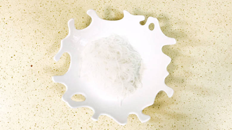 凉拌粉丝黄瓜,粉丝烫软后,控干水分,加入碗里