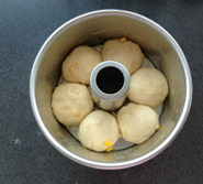 鲜奶玉米面包,均匀地排入模具，盖保鲜膜进行最后发酵2倍大小，约40分钟，表面刷全蛋液，入预热180度的烤箱中下层，烤25分钟至表面金黄，取出后立即脱模晾凉