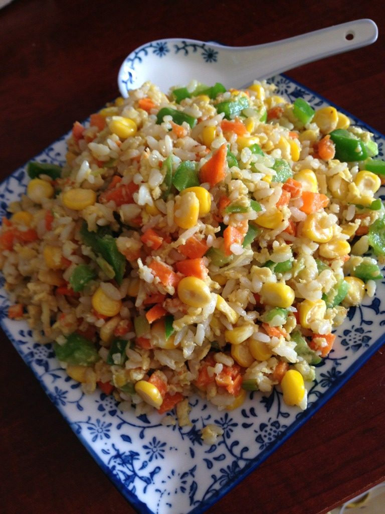 五彩缤纷的炒饭,锅里热油（不可以太少会粘锅），放入葱姜蒜爆炒一下倒入拌好的米饭、材料，加入盐、少许酱油、鸡精（本人是不吃鸡精、味精的）不停翻炒，炒到米饭一粒粒就可以出锅