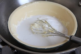 南洋风味的奶酪蛋糕——椰香奶酪蛋糕 ,材料B奶油奶酪在室温软化后,加细砂糖用隔水加热方式,用打蛋器搅拌使奶油奶酪呈无颗粒的光滑状,再分别加入椰浆和椰子粉,用打蛋器搅拌均匀。