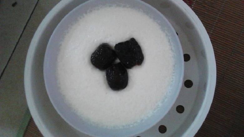 蜜枣双皮奶,两杯牛奶倒入锅里煮热,直至表面有一层皱皮。