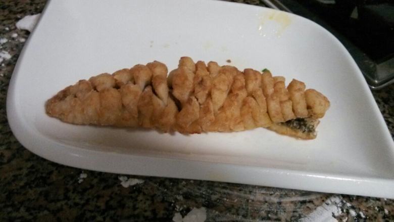 家庭版简单松鼠鱼,油热了。把鱼肉上多余的淀粉抖落。入油锅,炸成金黄色