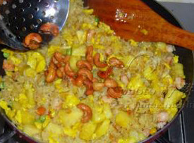 泰式菠萝海鲜炒饭 ,倒入炒好的鸡蛋和虾仁翻炒两下，再倒入菠萝粒翻炒几下，倒入炸好的腰果拌拌即可