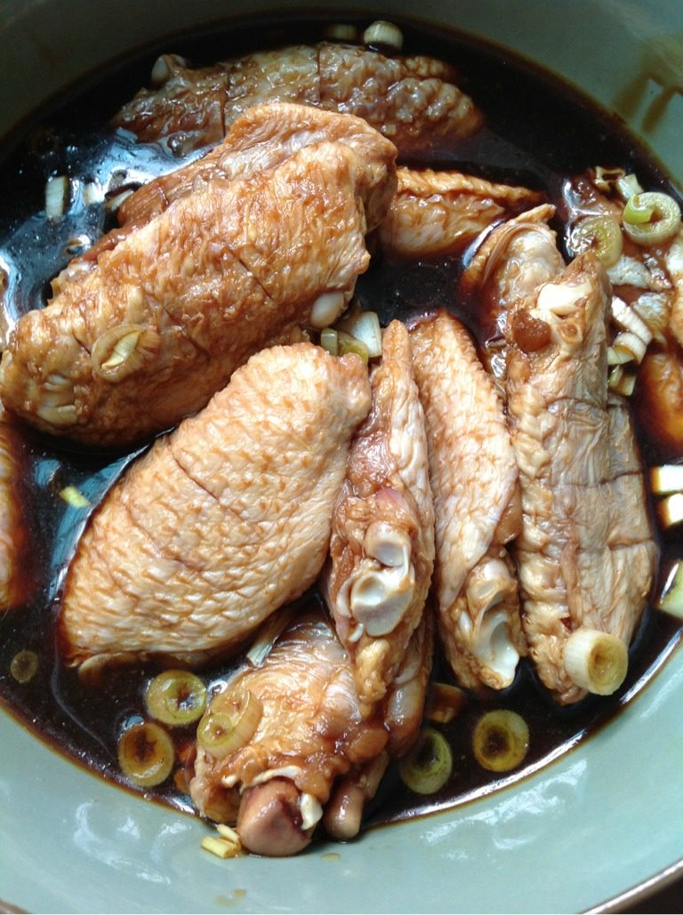 麻辣香锅鸡翅,如图，将鸡翅放入大碗内，加入蒜片，葱花，<a style='color:red;display:inline-block;' href='/shicai/ 718'>料酒</a>，<a style='color:red;display:inline-block;' href='/shicai/ 692'>酱油</a>，搅拌均匀，泡1〜1.5小时，使鸡翅充分入味