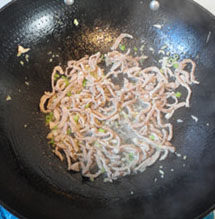 蚝油肉丝炒海带,热锅凉油，加入肉丝，放入姜、蒜、葱一起炒香
