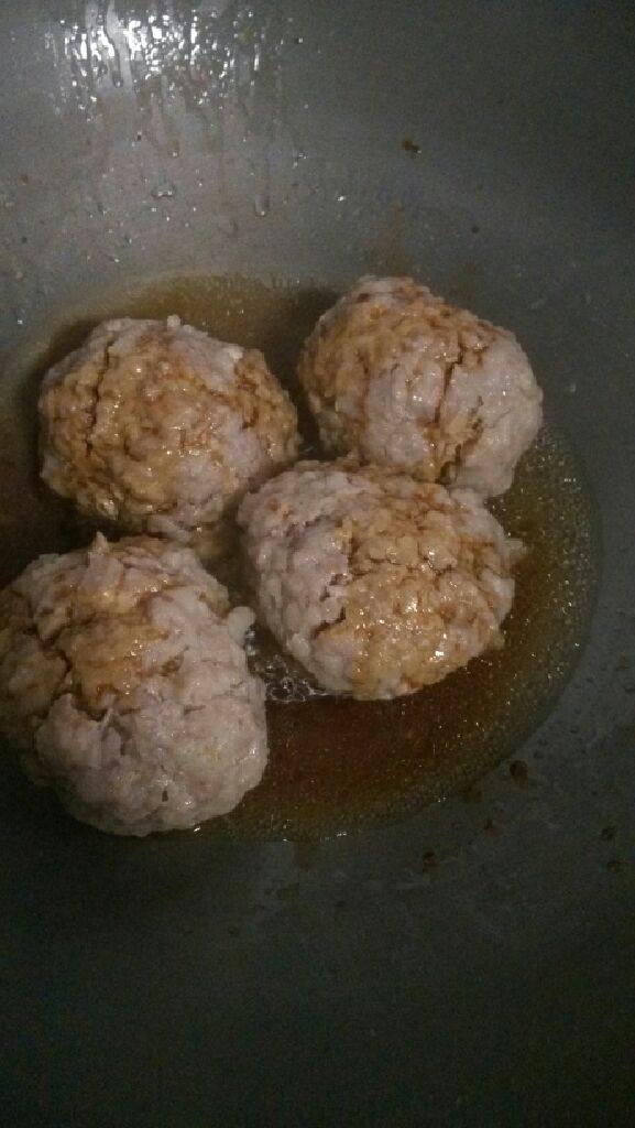 红烧狮子头,碗里抹油，放进肉丸蒸熟。锅里放水，生抽，老抽，冰糖。把蒸熟的肉丸和汤汁一起倒进锅。大火烧开，收汁。起锅，撒点葱花。