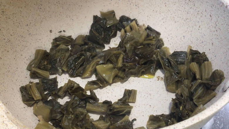 酸菜炖鲫鱼,就着热锅放入酸菜,煸炒出香味,再淋入少许菜籽油,炒匀
