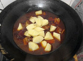番茄土豆焖排骨,煮的过程中将<a style='color:red;display:inline-block;' href='/shicai/ 23'>土豆</a>去皮切滚刀块，<a style='color:red;display:inline-block;' href='/shicai/ 61'>青椒</a>切小块备用，15分钟后，开盖放入<a style='color:red;display:inline-block;' href='/shicai/ 23'>土豆</a>块，继续中小火焖15分钟