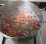 罗宋汤,牛肉煮烂后,捞出香叶不要,下入芹菜丁、土豆丁、胡萝卜丁和洋葱丁,转小火慢炖至土豆熟烂;
