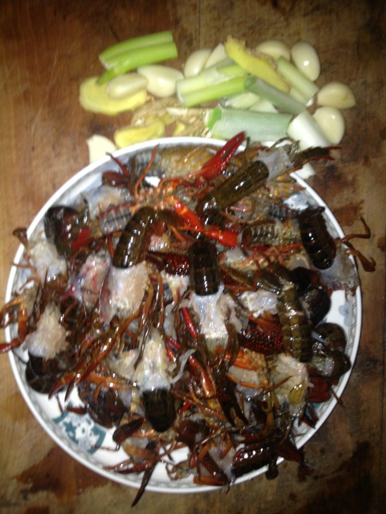 海鱼炒小龙虾,锅里加油,平时炒菜的两倍吧。油热后先下生姜,炸至金黄后下葱蒜辣椒干,大概翻炒一下就放入洗净的虾尾。大火翻炒虾尾变红后加水,覆盖虾尾就好。