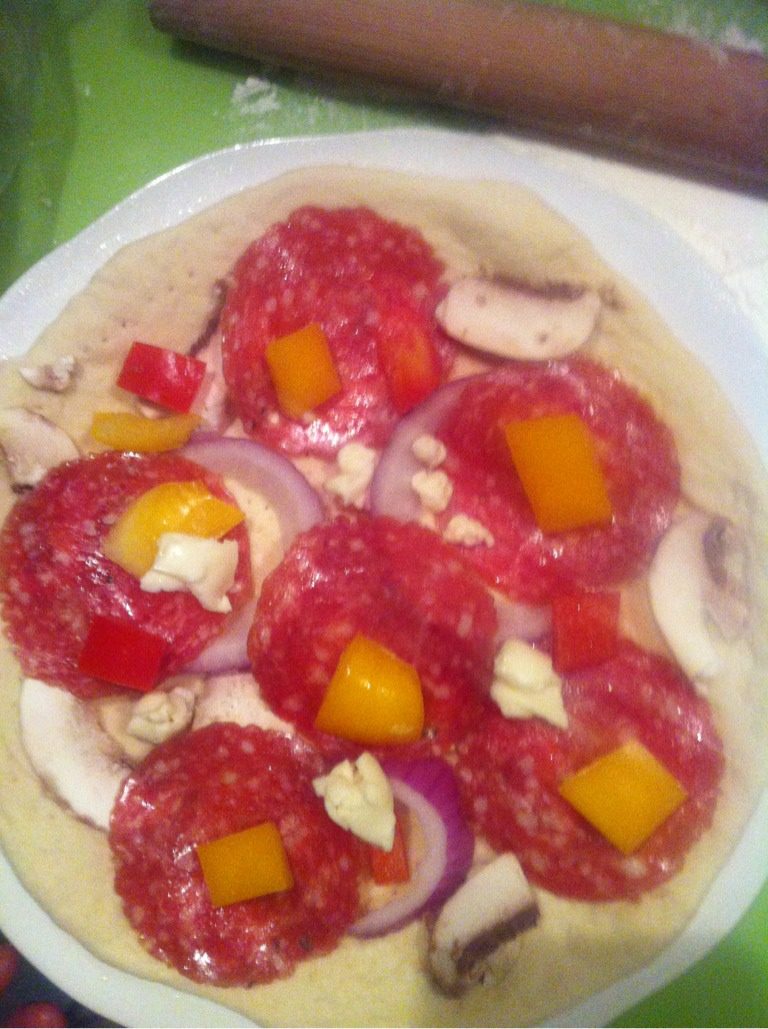 自制意大利pizza……,开始撒好吃的啦,先是蔬菜,然后肉类,最后放大量的奶酪,加少许的黄油粒。