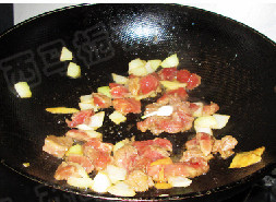 黑椒苹果牛肉粒,取出苹果皮,把腌制好的牛肉粒滑入锅中,加入大蒜同时翻炒