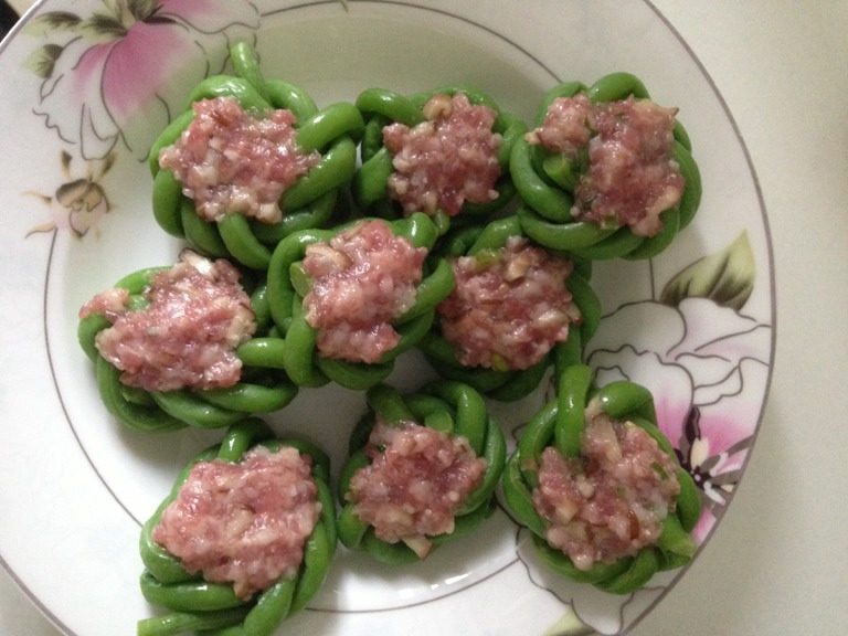 酿豆角花,如图将肉酿入豆角花内,备用。