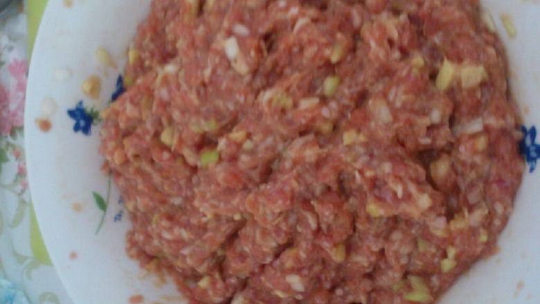 津味儿豆角焖肉丸,肉馅加葱姜末、五谷鲜、盐、油调味,加一个蛋清顺时针搅匀。